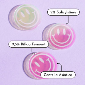 Drei durchsichtige Pimple Buddy Hydrocolloid Patches von INAO by essence tragen die Aufschriften "2% Salicylsäure", "0,5% Bifida Ferment" und "Centella Asiatica" auf violettem Hintergrund, darunter ein deutscher Text, der zur Erforschung der Inhaltsstoffe einlädt.