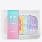 Ein durchsichtiger Beutel mit Reißverschluss enthält sieben pastellfarbene, wiederverwendbare Swipe Tribe Make-up-Entferner-Pads von INAO by essence für eine sanfte Reinigung. Auf der Verpackung steht „INAO by essence“.