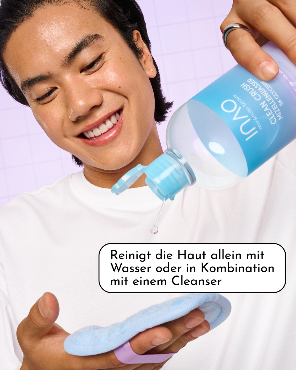 Lächelnde Person gießt INAO Clean Crush Mizellenwasser auf ein blaues Make-up-Entferner-Pad, mit dem Hinweis „Reinigt die Haut allein mit Wasser oder in Kombination mit einem Cleanser“.
